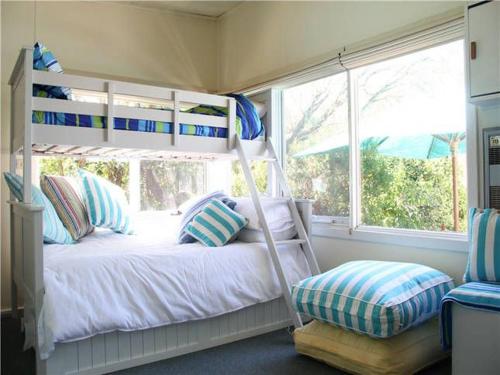 1 dormitorio con litera y ventana en Blairgowrie Beach Escape, en Blairgowrie