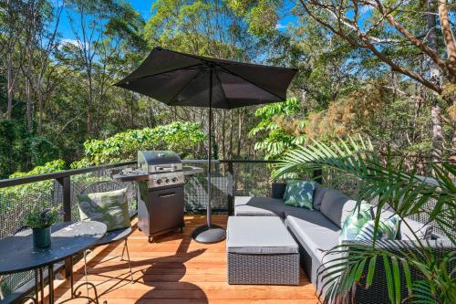 a patio area with chairs, tables and umbrellas at Noosa Hinterland Retreat in Tinbeerwah