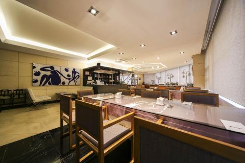 a restaurant with a bar with chairs and tables at Benikea Hotel Bizinn in Wonju
