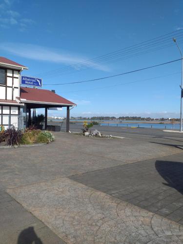 un parcheggio vuoto accanto a una stazione di servizio di Albatross Motel a Napier