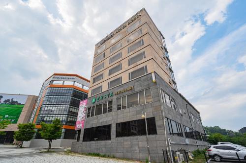 a tall building with a sign on the side of it at Benikea Hotel Bizinn in Wonju