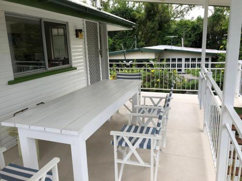 a white table and chairs on the porch of a house at Daggoombah Holiday Home Magnetic Island in Arcadia