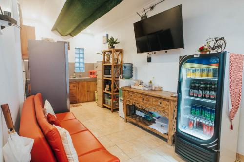 a living room with an orange couch and a refrigerator at Dong Jegeg Canggu in Canggu