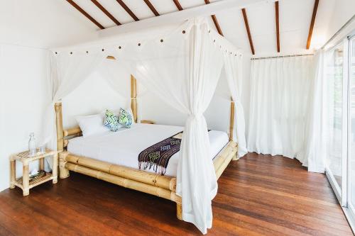 a bedroom with a bed with a canopy at The Seraya Resort Komodo in Labuan Bajo