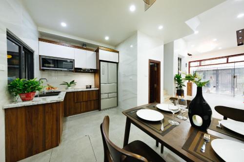 cocina y comedor con mesa de madera y sillas en Hi Home Residences Ba Dinh Ha Noi, en Hanói