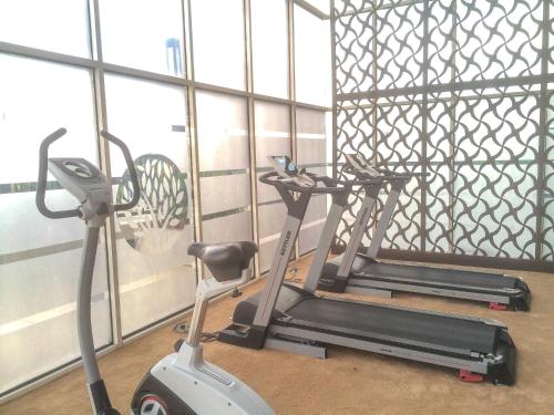 a gym with two tread machines in a room at Cozy 1BR Oasis Apartment By Travelio in Bekasi