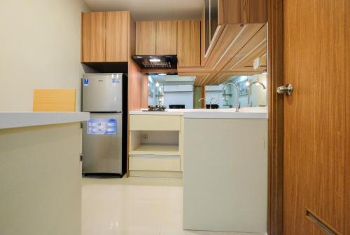 a kitchen with white counters and a refrigerator at Cozy 1BR Oasis Apartment By Travelio in Bekasi