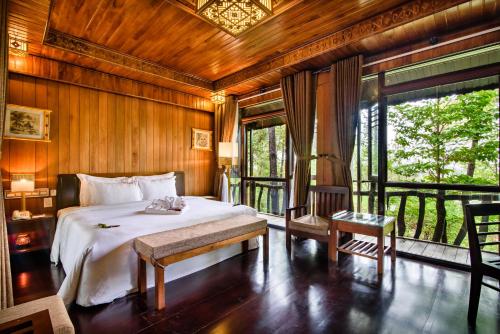 une chambre avec un lit et une grande fenêtre dans l'établissement Sankofa Village Hill Resort & Spa, à Hue