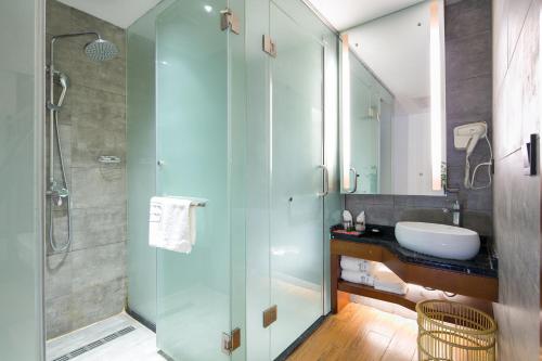 een badkamer met een glazen douche en een wastafel bij All Seasons Lodge in Zhangjiajie