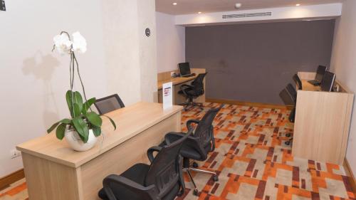 an office with chairs and a desk with a flower at Sovereign Bali Hotel in Kuta