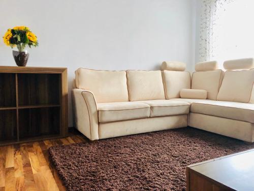 a living room with a white couch and a table at Little cute homey apartman in Satu Mare