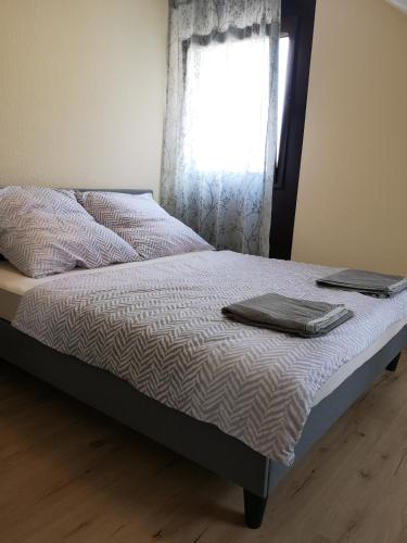 a bed with two towels on it with a window at Kamus in Baden-Baden