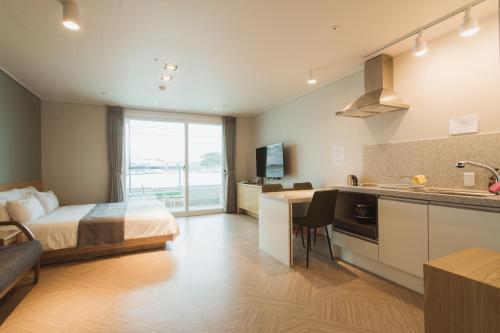 a hotel room with a bed and a kitchen at Lium Spa Hostel in Yeosu