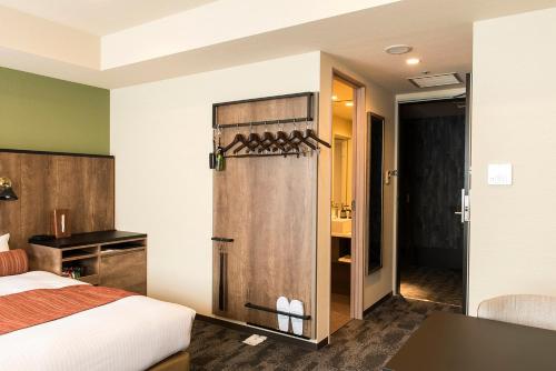 a bedroom with a bed and a shower in a room at Rembrandt Style Sapporo in Sapporo