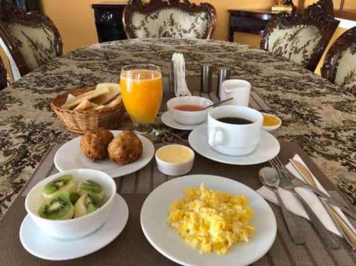 a breakfast table with plates of food and drinks at Kinde House in Quito