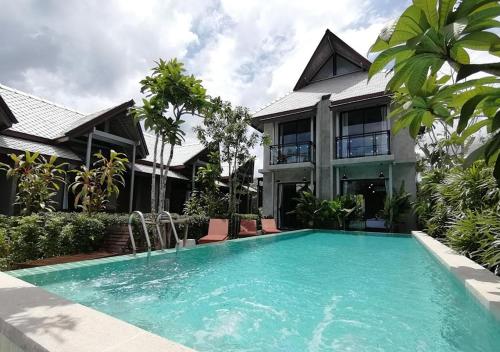 una piscina frente a una casa en JR Place en Klong Muang Beach