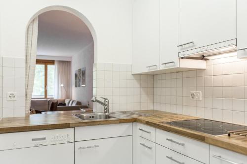 a white kitchen with a sink and a counter at Residenz Alpina 115 in Lenzerheide