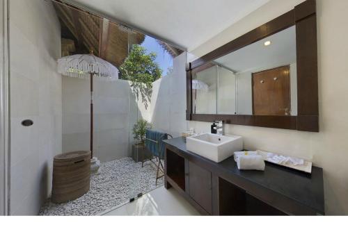 a bathroom with a sink and a mirror at Bali Agung Village - CHSE Certified in Seminyak