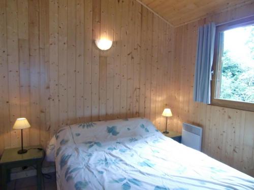 a bedroom with a bed in a room with a window at Chalet en Auvergne -Pêche in Roumégoux