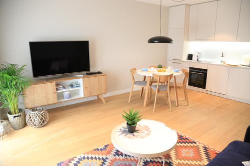 uma sala de estar com uma televisão e uma mesa em Lake View Apartment em Iława