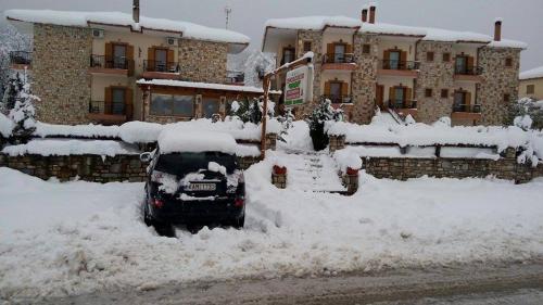 a car covered in snow in front of a building at Hotel Orama in Kryonérion