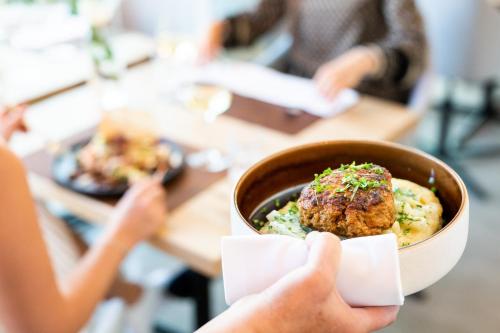a person holding up a bowl of food at Schwan und Post Business Quarters in Bad Neustadt an der Saale