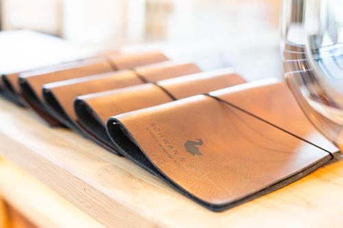 a brown wallet sitting on a table next to a glass at Schwan und Post Business Quarters in Bad Neustadt an der Saale
