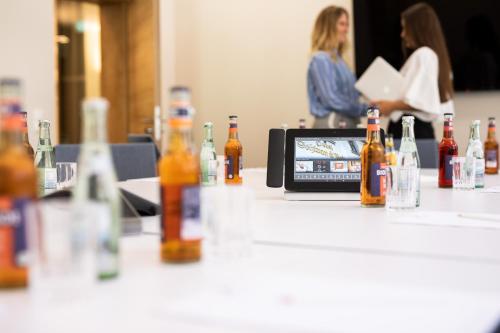 a table with bottles of alcohol on it with a cell phone at Schwan und Post Business Quarters in Bad Neustadt an der Saale