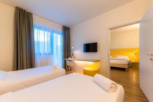 a hotel room with two beds and a mirror at Airport Hotel Bergamo in Bagnatica