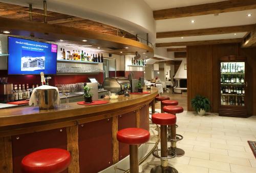 a bar in a restaurant with red stools at Sporthotel Kühtai in Kühtai
