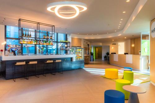 a bar in a hotel lobby with colorful stools at Airport Hotel Bergamo in Bagnatica