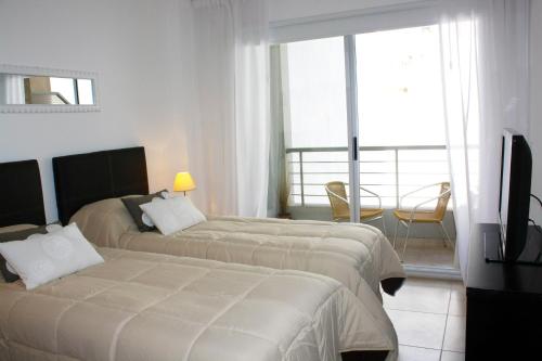 a hotel room with two beds and a television at Arenales Suites in Buenos Aires