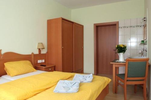 1 dormitorio con cama, escritorio y lavamanos en Gasthof Gnasmüller, en Totzenbach