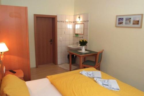ein Schlafzimmer mit einem Bett und ein Badezimmer mit einem Waschbecken in der Unterkunft Gasthof Gnasmüller in Totzenbach