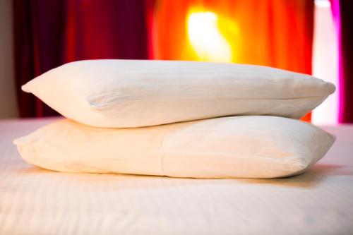 three pillows stacked on top of each other on a bed at Hotel Ganpati Palace in Mathura