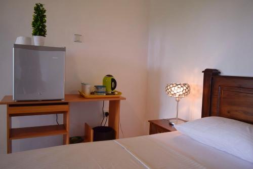 1 dormitorio con 1 cama y escritorio con TV en City Breeze Residence, en Kandy