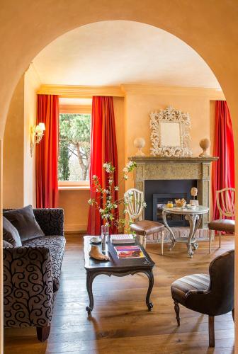 a living room with red curtains and a fireplace at L'Andana Tenuta La Badiola in Castiglione della Pescaia