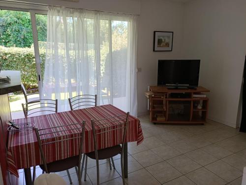 a dining room with a table and a television at Colline de la bergerie in Cambo-les-Bains