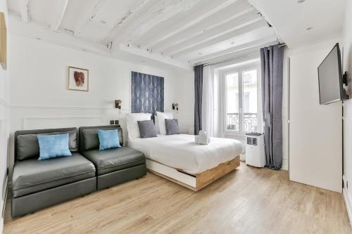 une chambre avec un lit et un canapé dans l'établissement 93 - Luxury Flat in Le Marais, à Paris