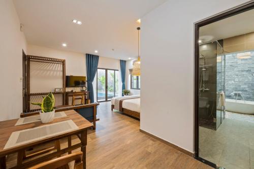 a bedroom with a bed and a bathroom with a shower at December Hoi An Villa in Hoi An