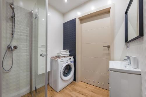 a bathroom with a washing machine and a shower at Klifowa Rewal, Sun & Snow in Rewal