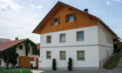 a large white house with a wooden roof at Ferienwohnung Dichtl in Grafenau