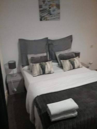 1 dormitorio con 1 cama con sábanas y almohadas blancas en Appartement Moderne 3 Chambres, en Fez