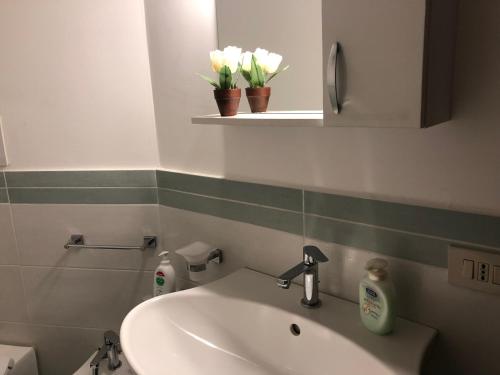a bathroom with a sink and a mirror and flowers at Great Sicily in Mondello