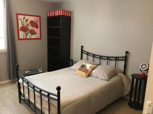 a bedroom with a black bed with two pillows at La pause nuitonne in Nuits-Saint-Georges