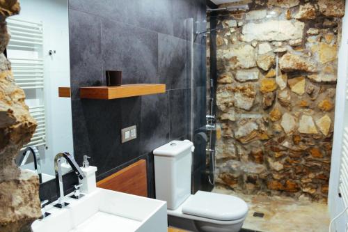a bathroom with a sink and a stone wall at Casa Plaza de Culla in Culla