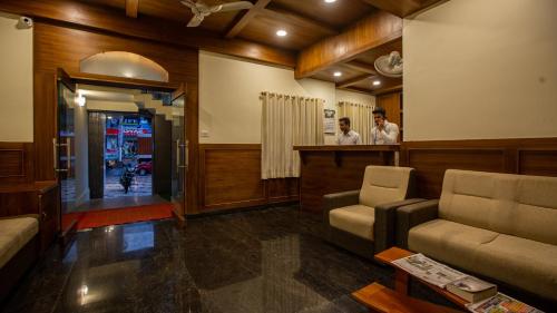 a lobby with a bar with two men standing at a counter at Woodside residency in Thekkady