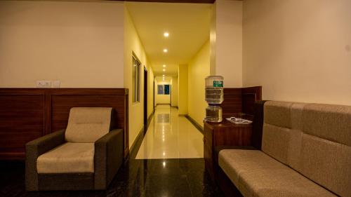 a waiting room with a chair and a bottle at Woodside residency in Thekkady
