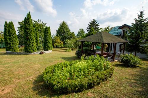 een tuinhuisje met een bank in een tuin bij Vikendica Ahatovići in Ahatovići