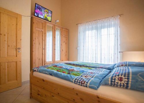 a bedroom with a bed with a tv on the wall at Ferienwohnung Haus Edelweiss in Winterberg